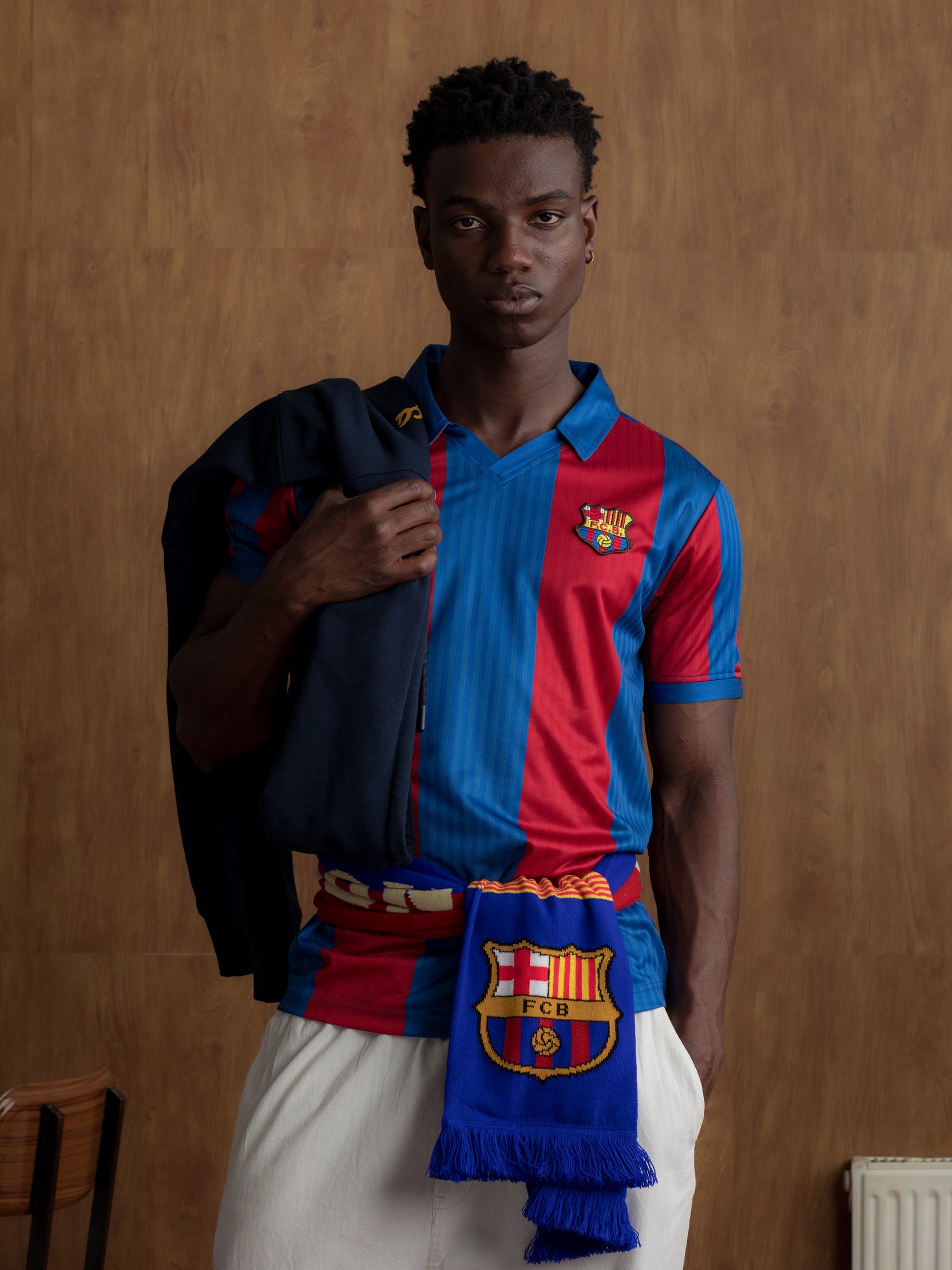 Man wearing a classic red and blue striped FC Barcelona jersey with matching scarf featuring the club crest.