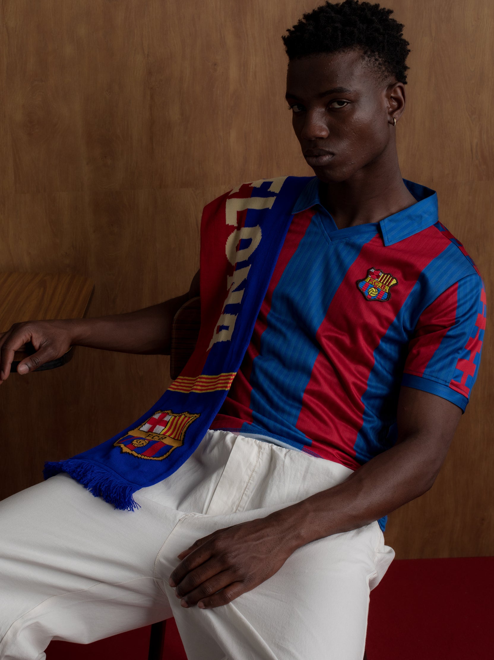 Man wearing a classic red and blue striped FC Barcelona jersey with matching scarf featuring the club crest.