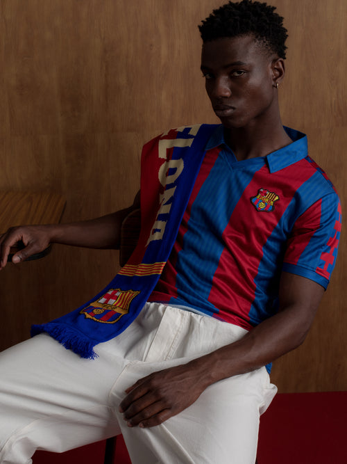 Man wearing a classic red and blue striped FC Barcelona jersey with matching scarf featuring the club crest.