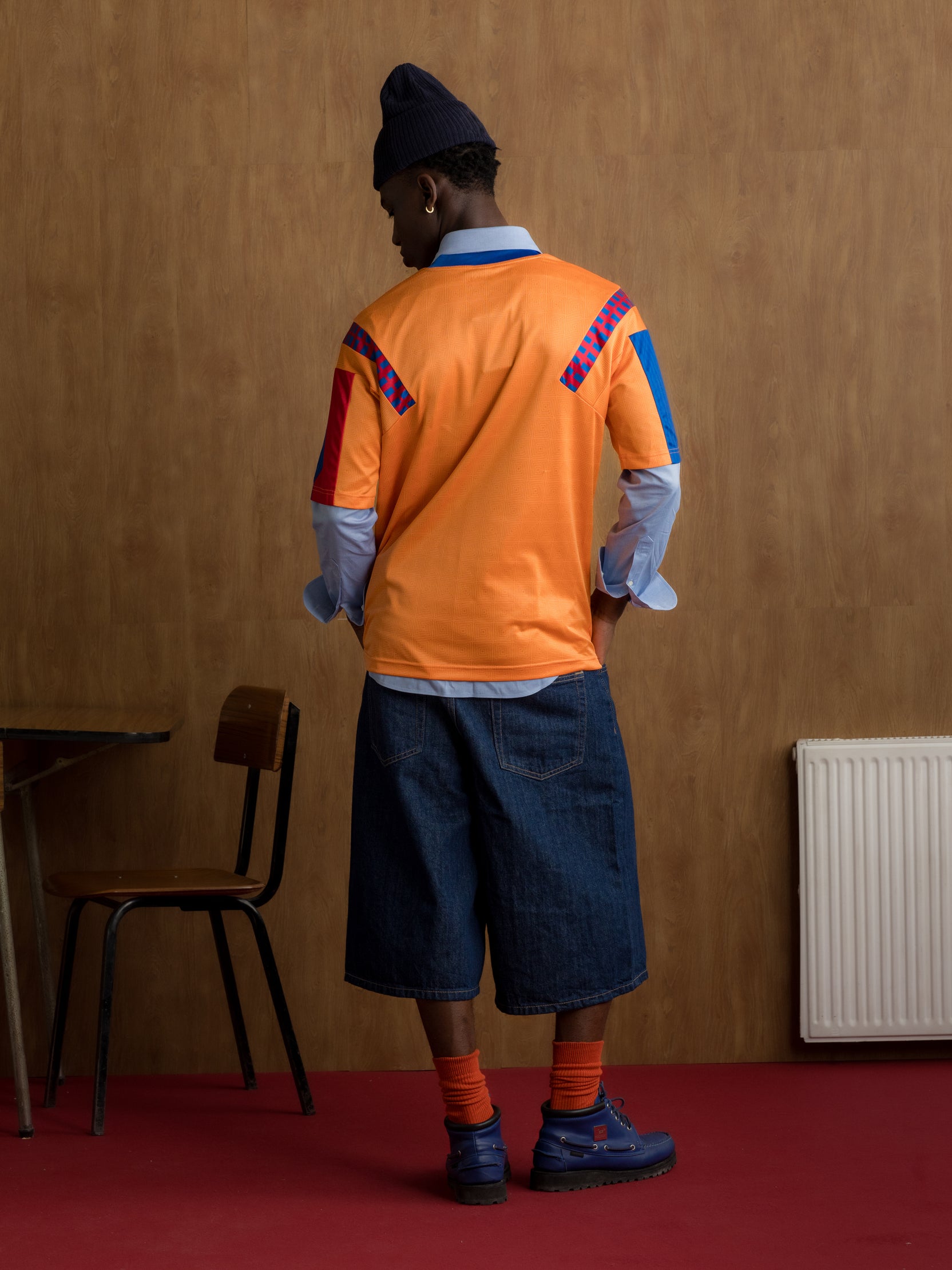 Orange retro-style FC Barcelona jersey with crest on the chest and red and blue details on the sleeves and shoulders.