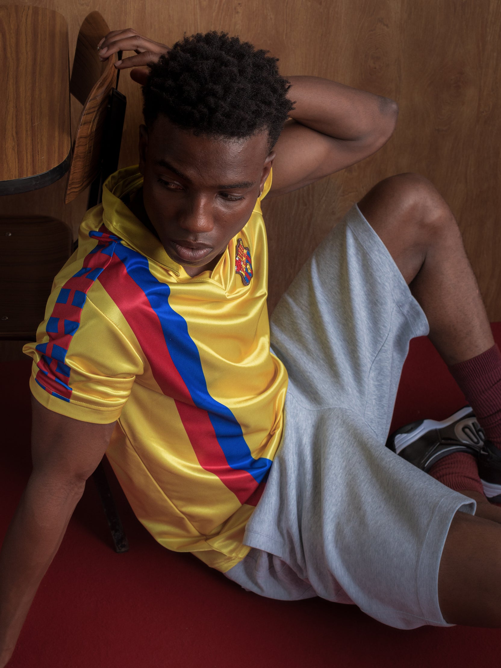 Yellow short-sleeve polo shirt with FC Barcelona crest and vertical red and blue stripe design.