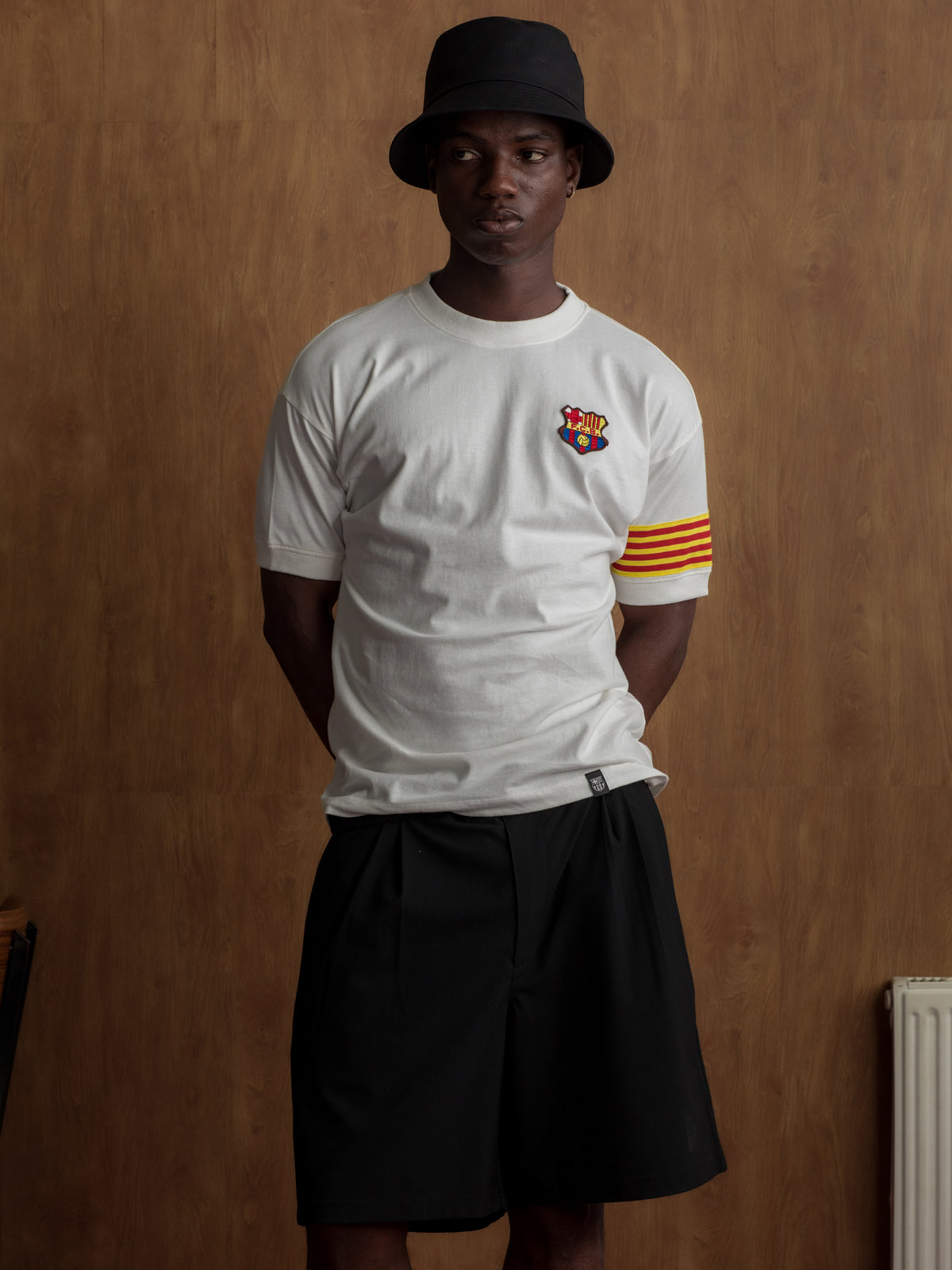 White T-shirt with FC Barcelona crest on the chest, Catalan flag detail on the sleeve, and red number 9 on the back.