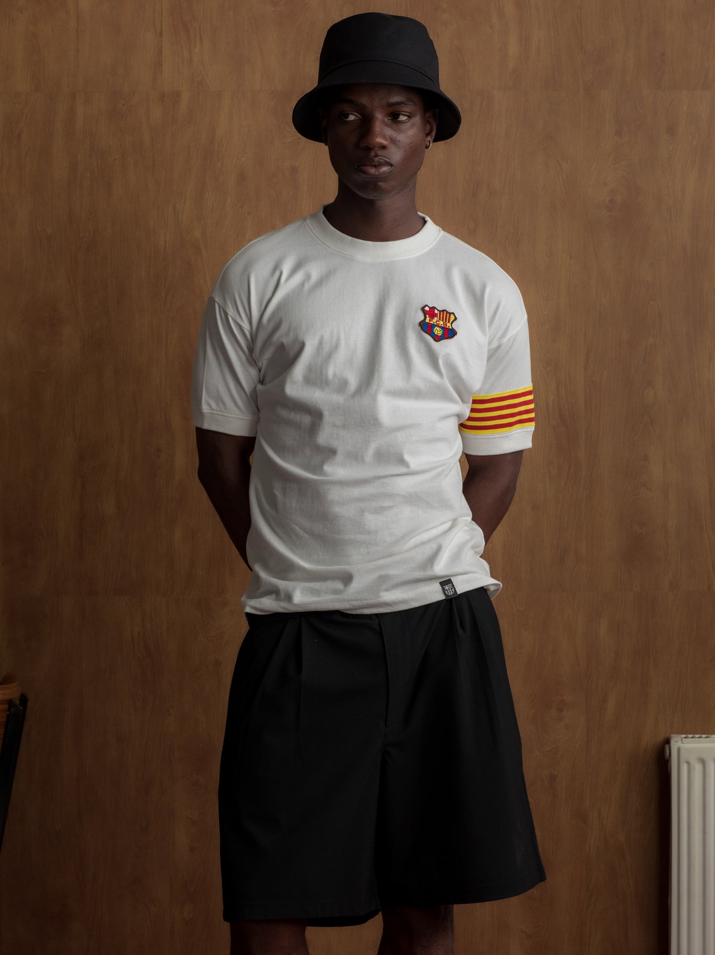 White T-shirt with FC Barcelona crest on the chest, Catalan flag detail on the sleeve, and red number 9 on the back.