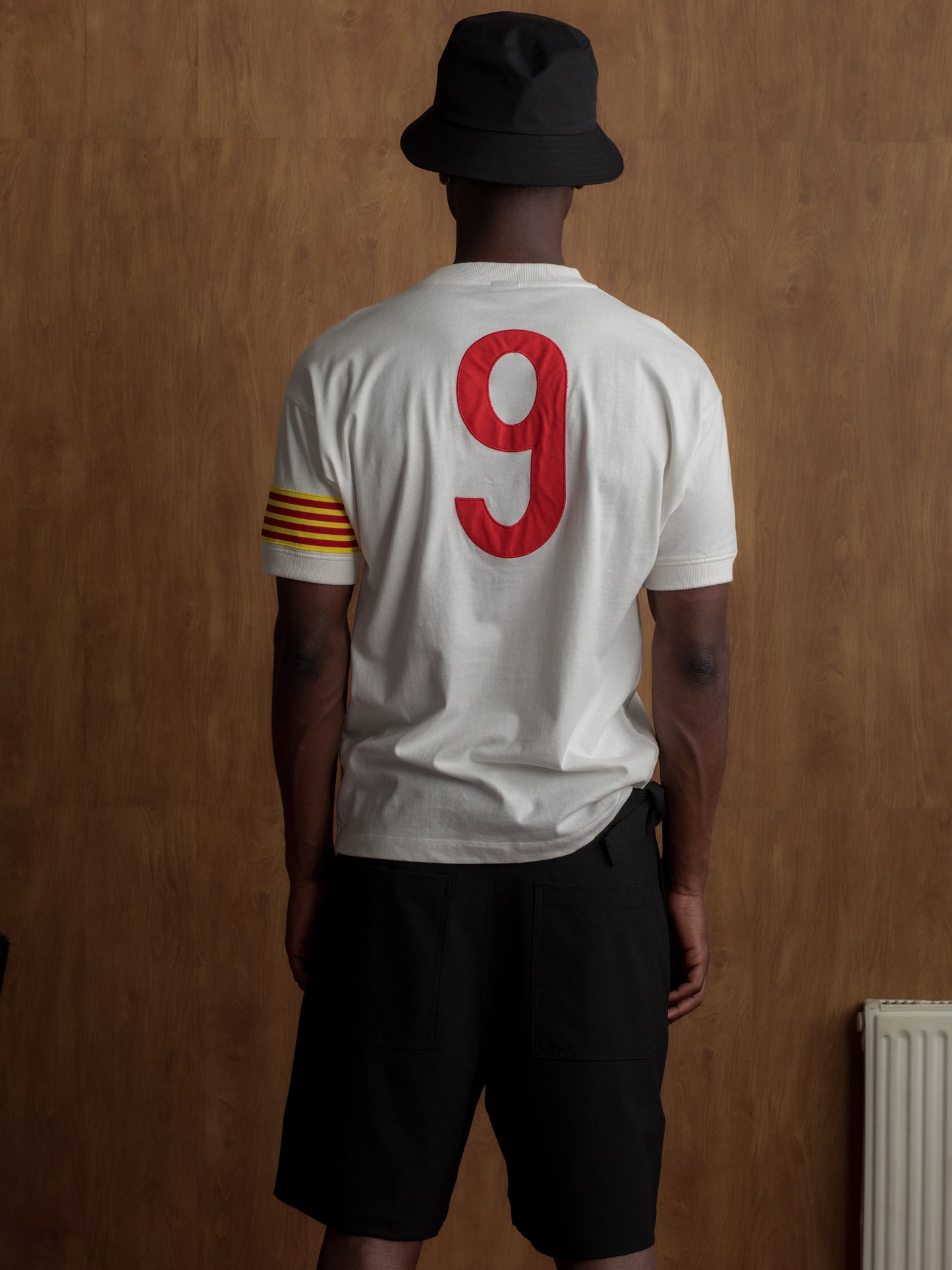 White T-shirt with FC Barcelona crest on the chest, Catalan flag detail on the sleeve, and red number 9 on the back.