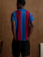 Man wearing a classic red and blue striped FC Barcelona jersey with matching scarf featuring the club crest.