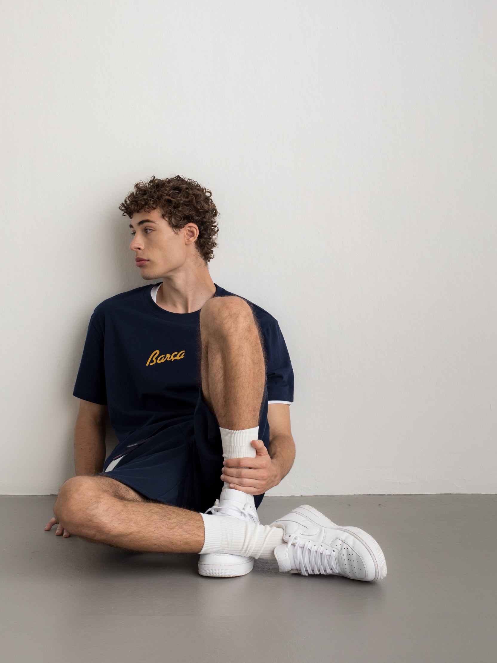Navy T-shirt with FC Barcelona crest and 'Més que un club' slogan printed on the back.