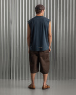 sleeveless navy blue FC Barcelona t-shirt with a small circular crest and text detail on the chest, paired with dark pants.