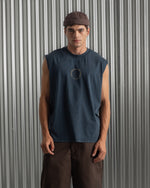 sleeveless navy blue FC Barcelona t-shirt with a small circular crest and text detail on the chest, paired with dark pants.