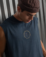 sleeveless navy blue FC Barcelona t-shirt with a small circular crest and text detail on the chest, paired with dark pants.