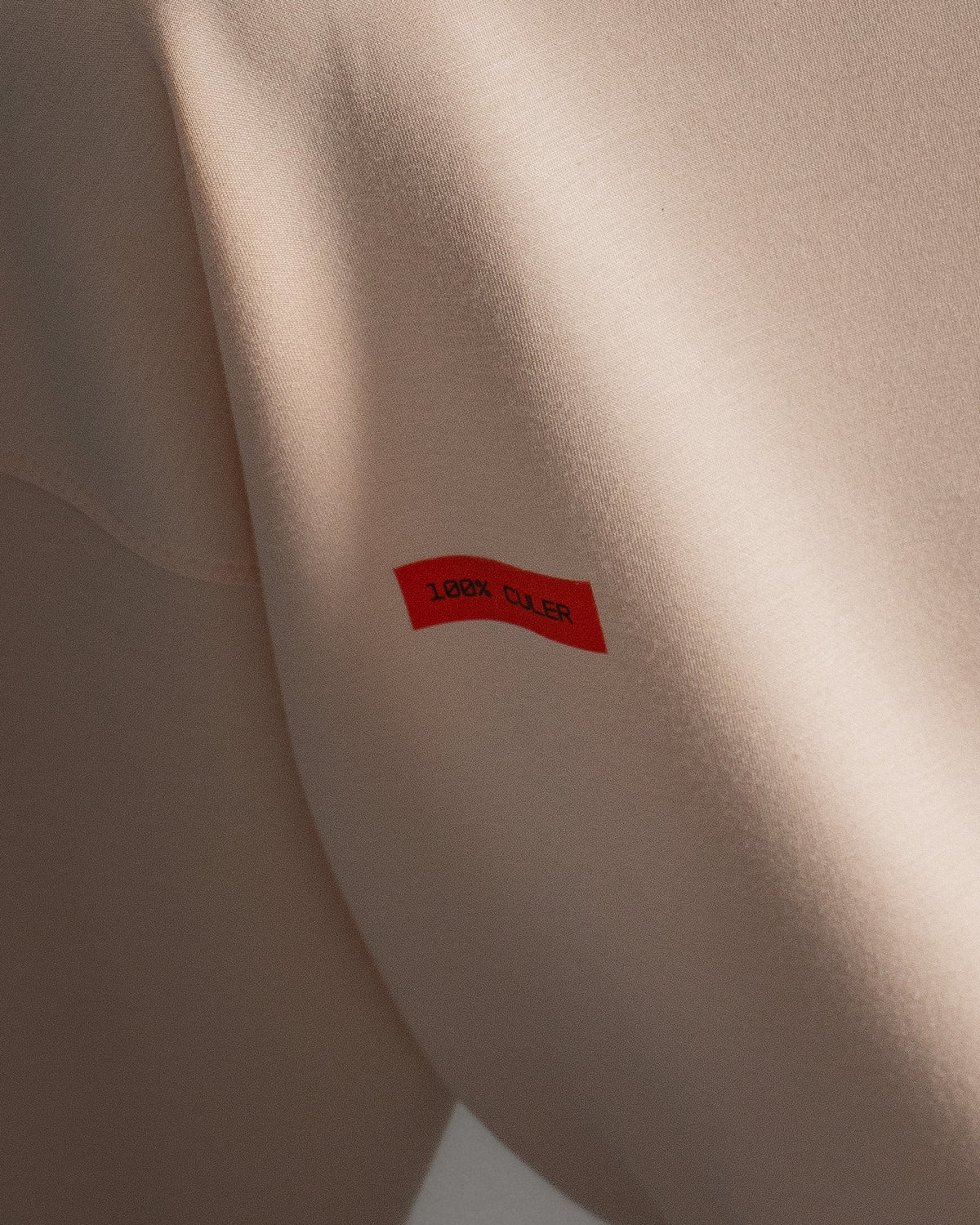 Light pink FC Barcelona sweatshirt with navy club crest on the chest and a small red rectangular detail on the left side.