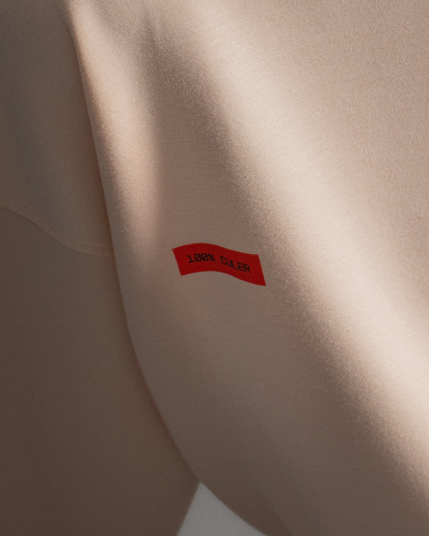 Light pink FC Barcelona sweatshirt with navy club crest on the chest and a small red rectangular detail on the left side.