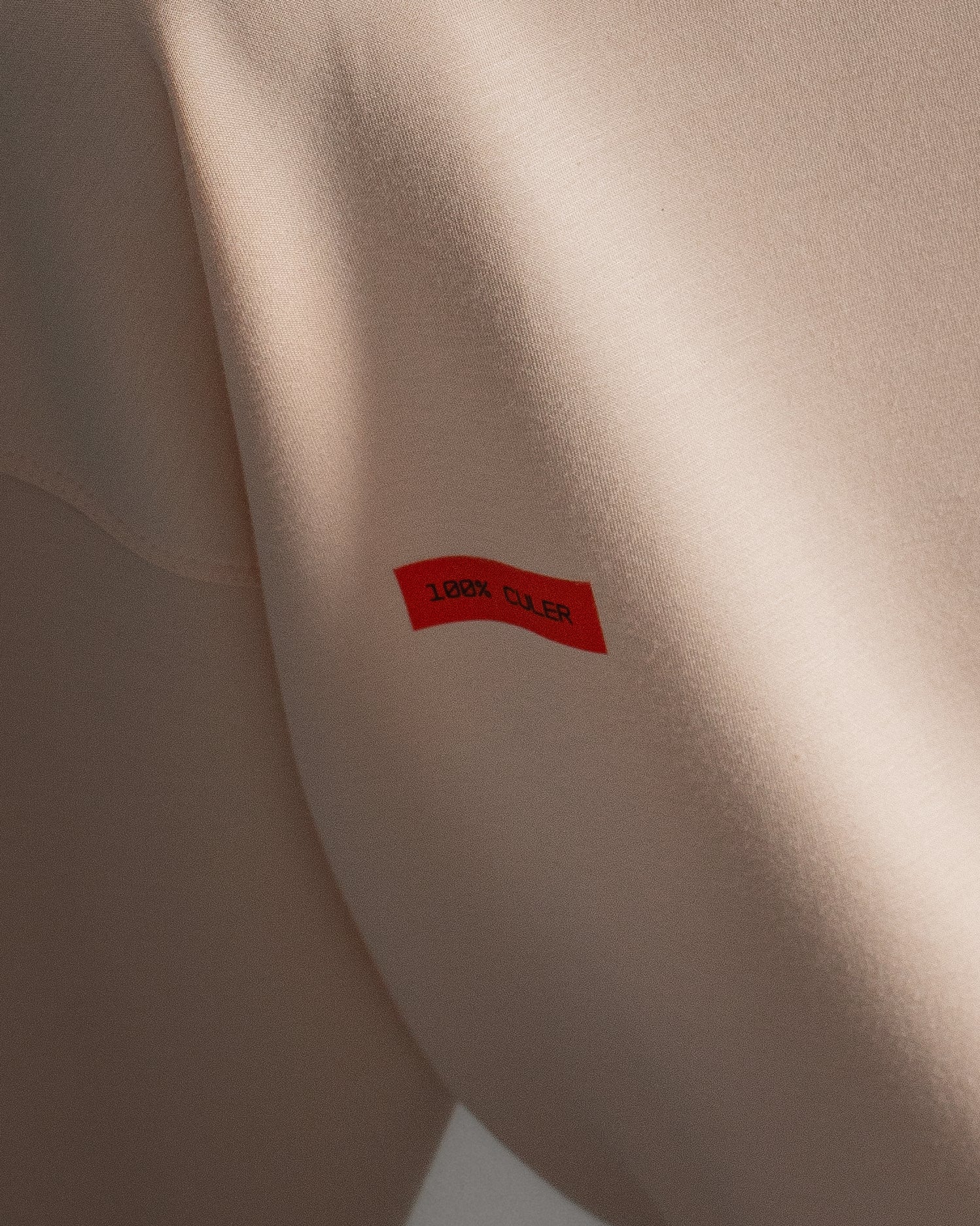 Light pink FC Barcelona sweatshirt with navy club crest on the chest and a small red rectangular detail on the left side.