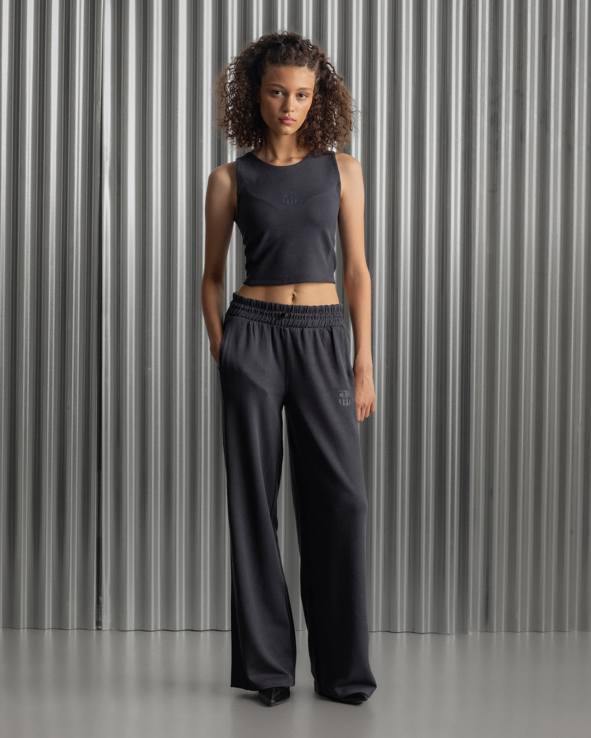 Black wide-leg pants with an elastic waistband and the FC Barcelona crest embroidered on the upper left thigh