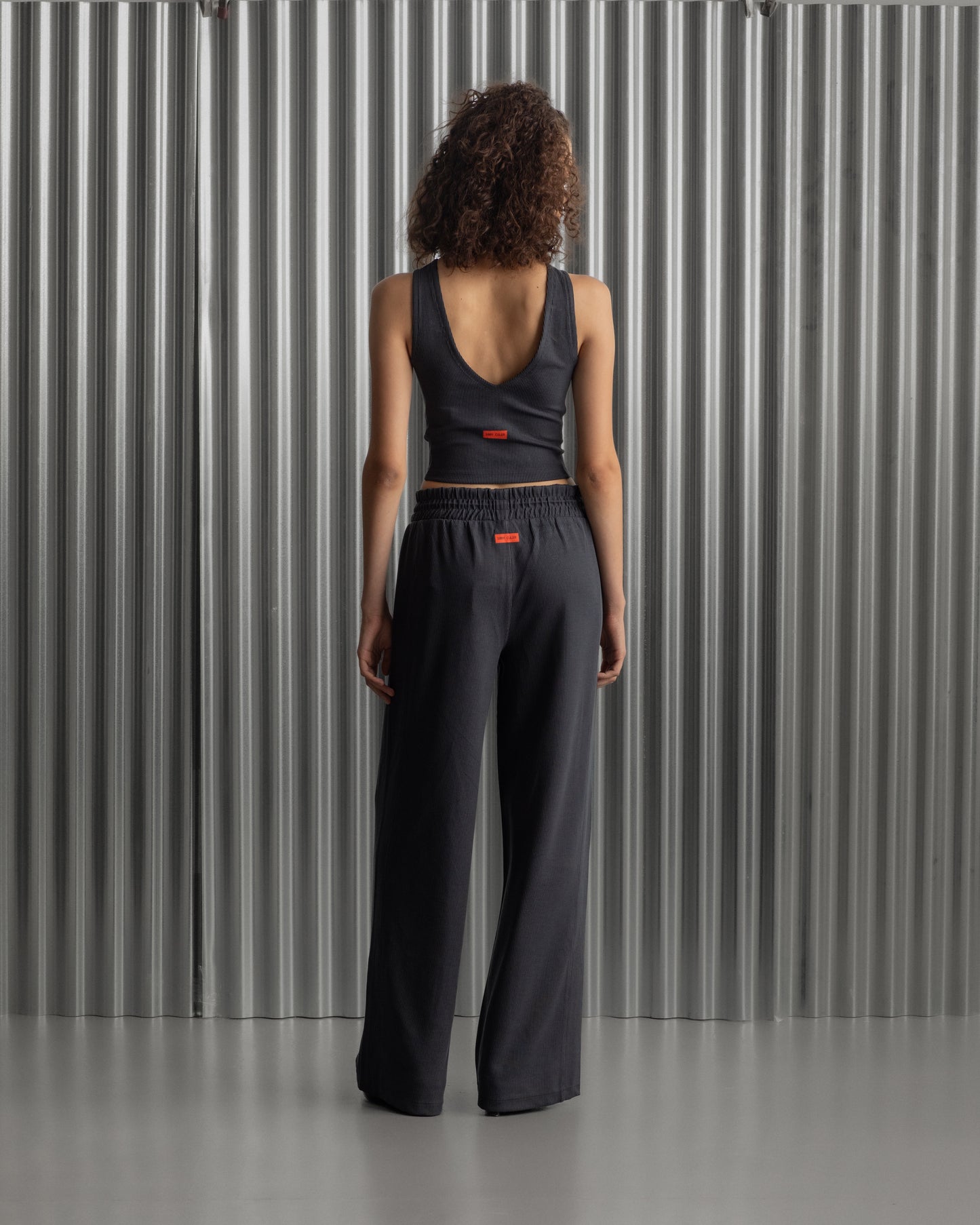 Black wide-leg pants with an elastic waistband and the FC Barcelona crest embroidered on the upper left thigh