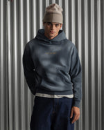 Man wearing a dark blue FC Barcelona hoodie with golden minimalist 'Barça' symbols printed on the chest