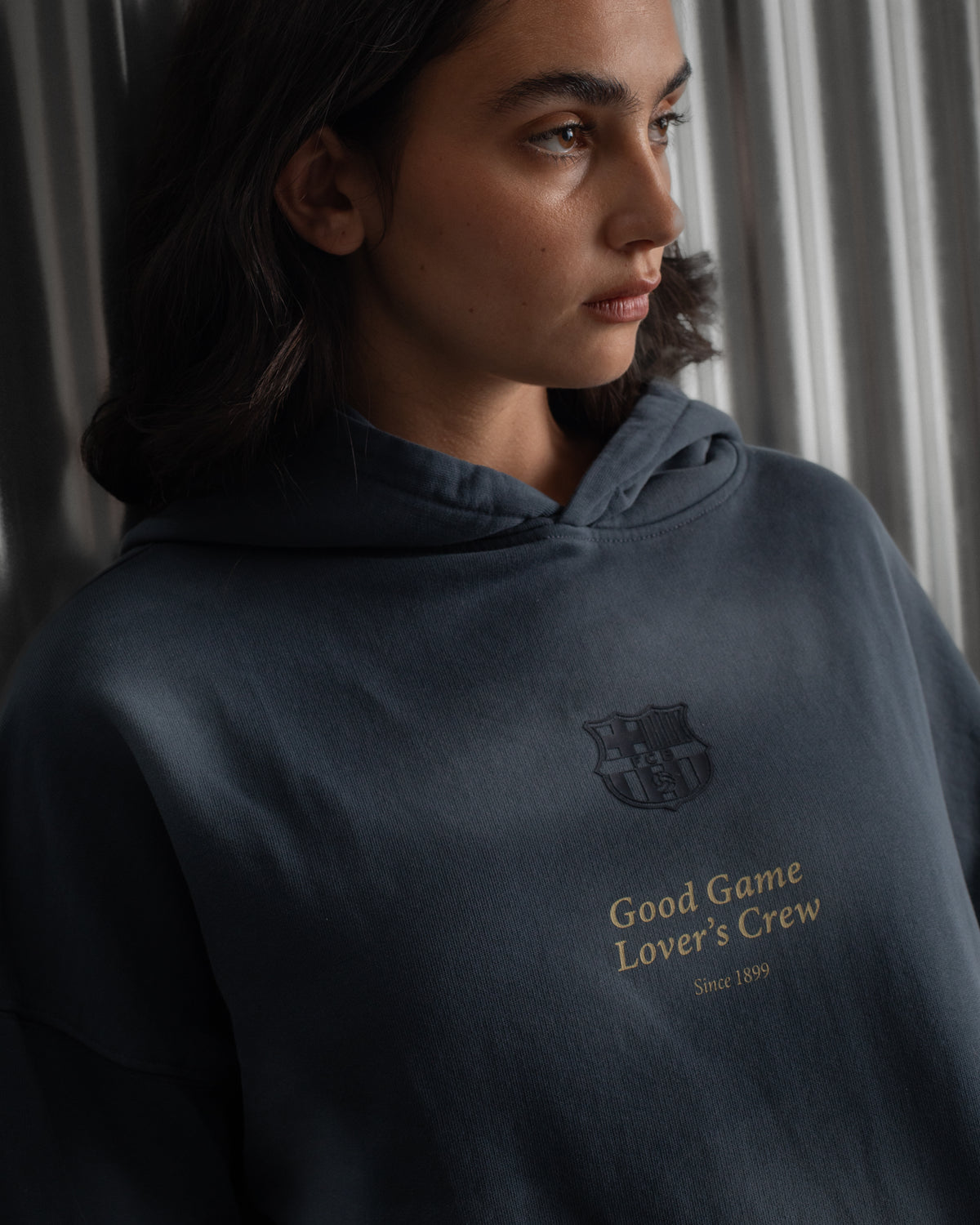 Dark blue FC Barcelona hoodie featuring the club crest and the phrase 'Good Game Lover’s Crew' embroidered on the front.