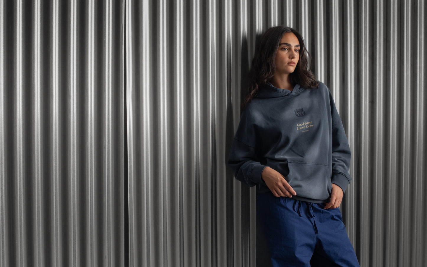 Dark blue FC Barcelona hoodie featuring the club crest and the phrase 'Good Game Lover’s Crew' embroidered on the front.