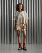 Beige cropped FC Barcelona t-shirt, back view, with gold FCB logo and the phrase “Good Game Lover’s Crew since 1899” printed in black above it.