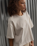 Beige cropped FC Barcelona t-shirt, back view, with gold FCB logo and the phrase “Good Game Lover’s Crew since 1899” printed in black above it.