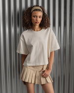 Beige cropped FC Barcelona t-shirt, back view, with gold FCB logo and the phrase “Good Game Lover’s Crew since 1899” printed in black above it.