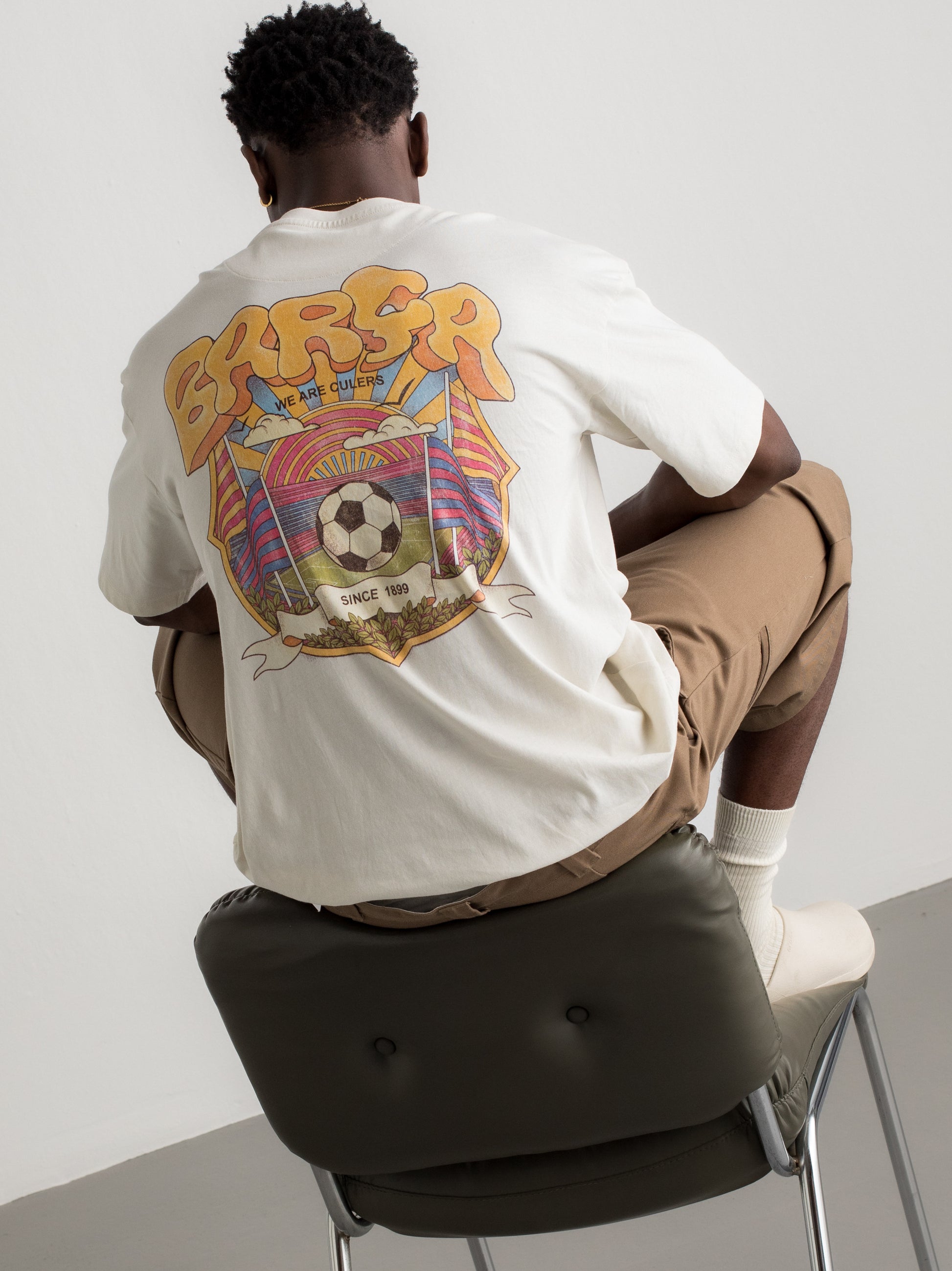 White T-shirt with colorful Barça graphic on the back featuring a football, flags, and dynamic typography