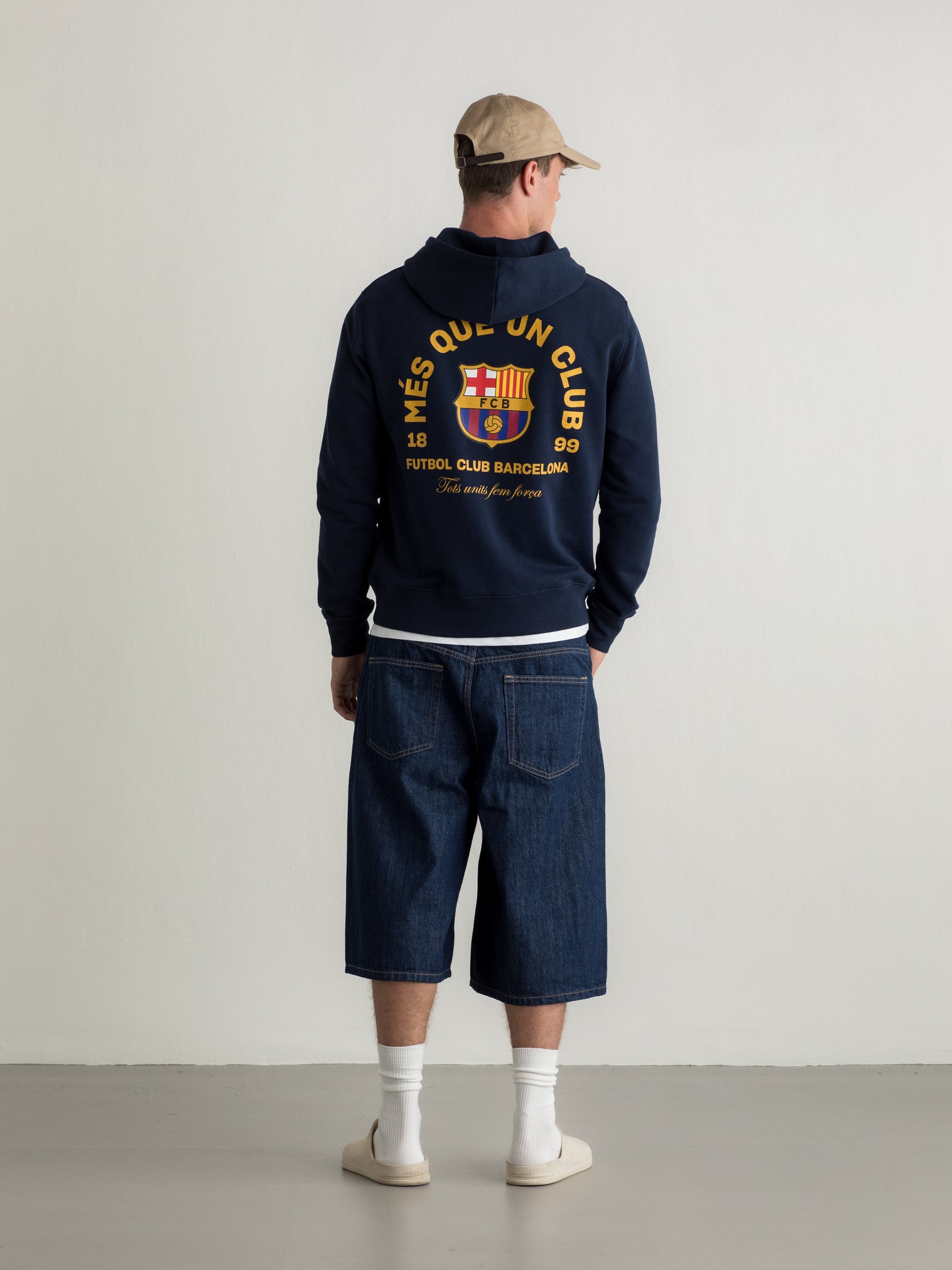 Navy hoodie with FC Barcelona crest and 'Més que un club' slogan printed on the back.