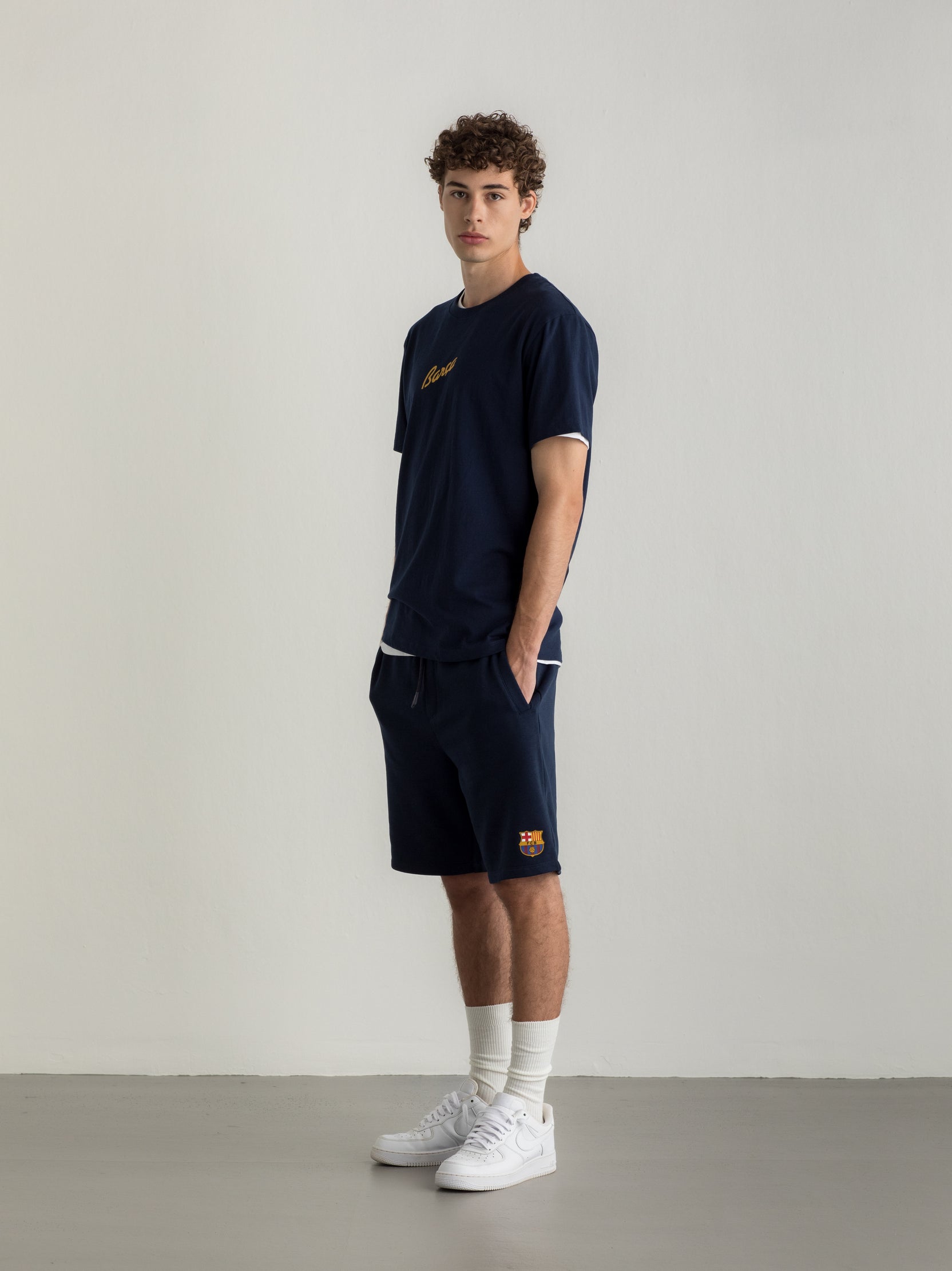 Navy T-shirt with FC Barcelona crest and 'Més que un club' slogan printed on the back.