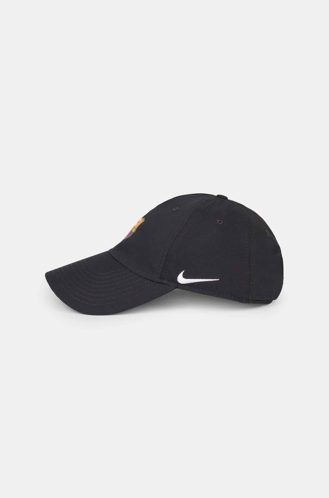 Black curved-brim cap featuring the FC Barcelona crest on the front and a white Nike swoosh embroidered on the side.