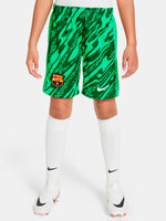 Person wearing green FC Barcelona goalkeeper shorts with abstract pattern, Nike logo, and club crest.