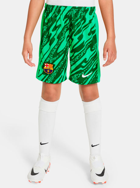 Person wearing green FC Barcelona goalkeeper shorts with abstract pattern, Nike logo, and club crest.