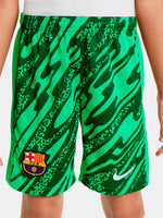 Person wearing green FC Barcelona goalkeeper shorts with abstract pattern, Nike logo, and club crest.