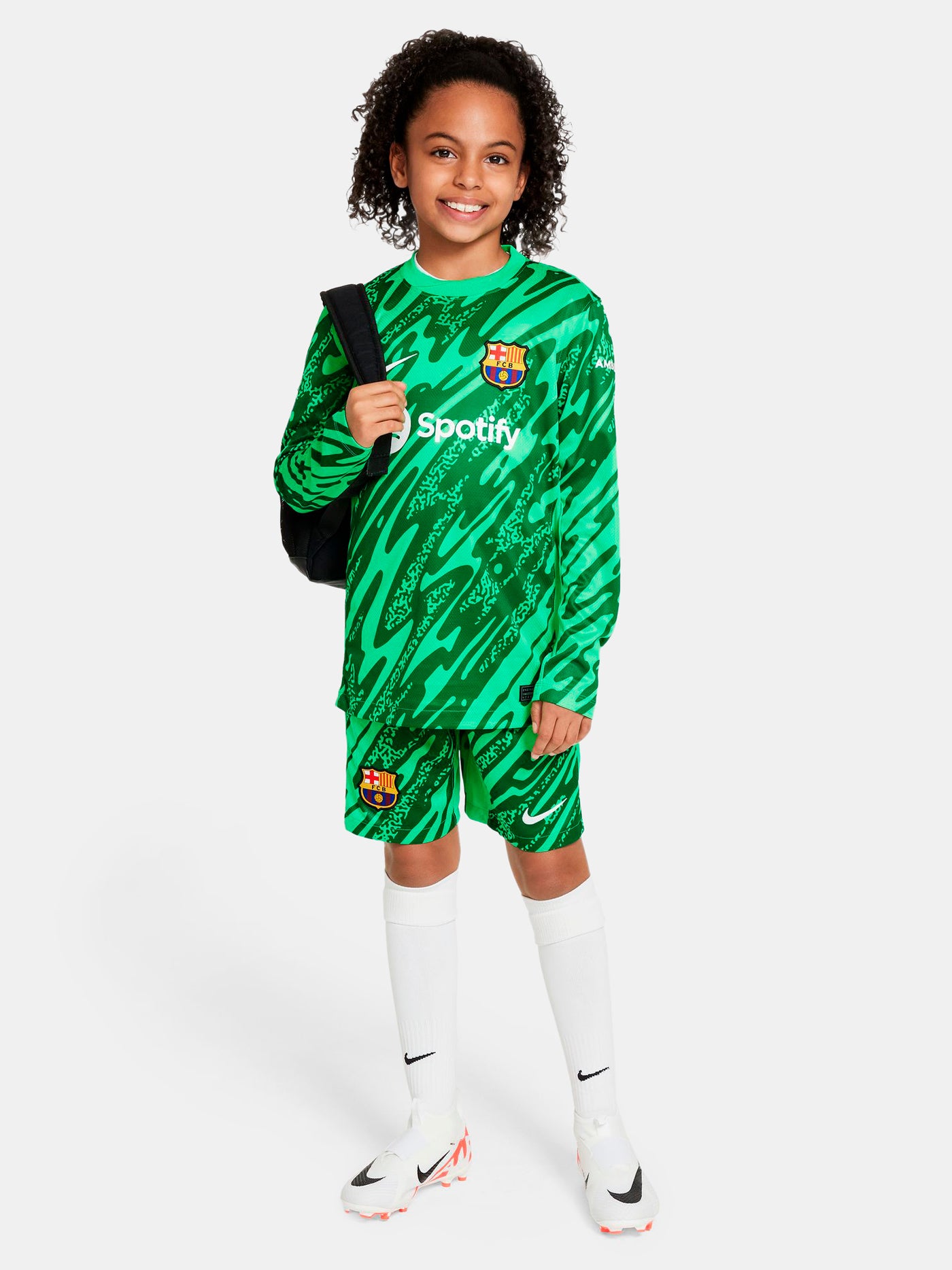 Person wearing green FC Barcelona goalkeeper shorts with abstract pattern, Nike logo, and club crest.
