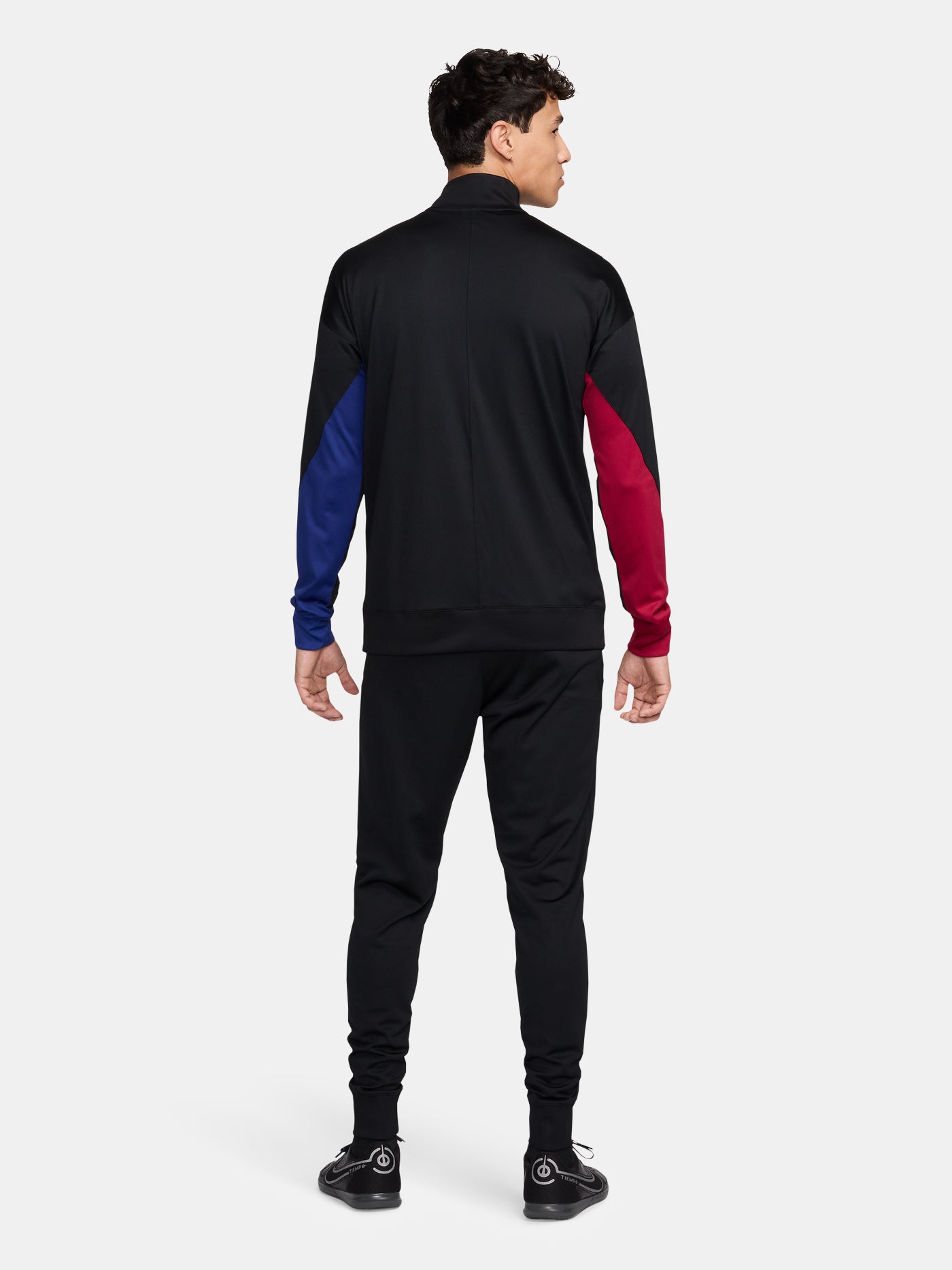 Black FC Barcelona tracksuit with red and blue sleeve cuffs, Nike logo and club crest.