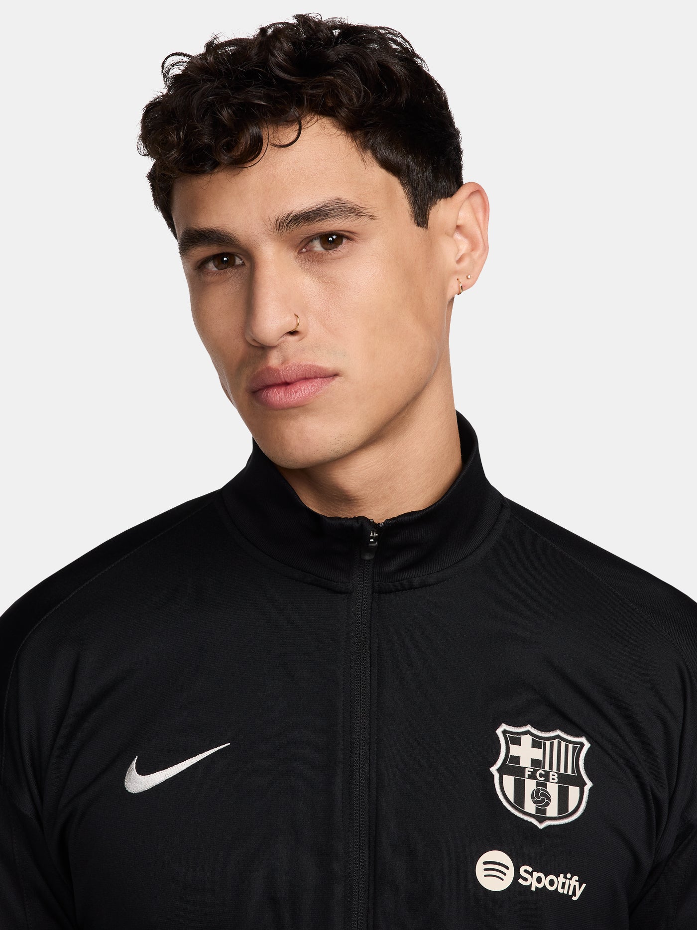 Black FC Barcelona tracksuit with red and blue sleeve cuffs, Nike logo and club crest.