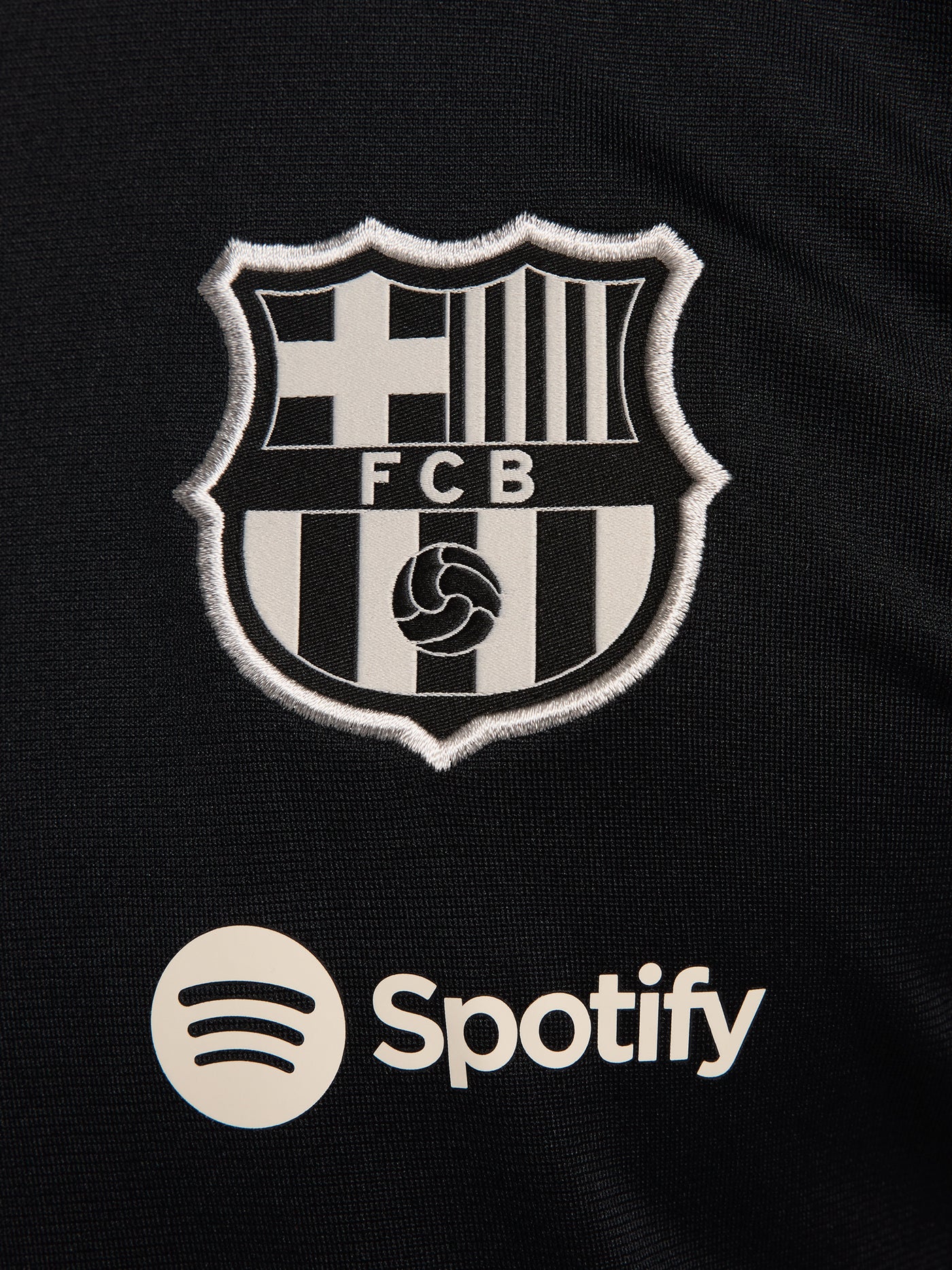 Black FC Barcelona tracksuit with red and blue sleeve cuffs, Nike logo and club crest.