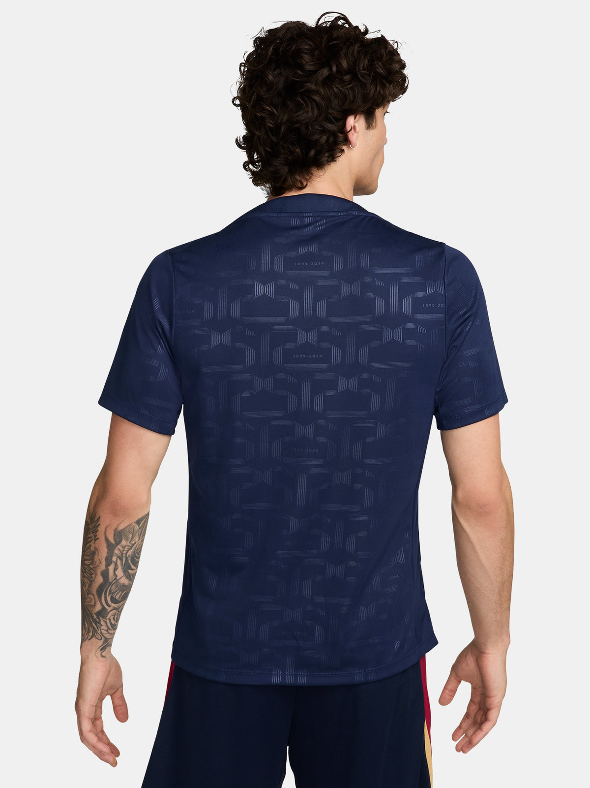 FC Barcelona training shirt in dark navy blue featuring subtle tonal geometric patterns. The shirt displays a golden Nike swoosh on the right chest, the FC Barcelona crest on the left chest, and a bold gold Spotify logo centered across the front.