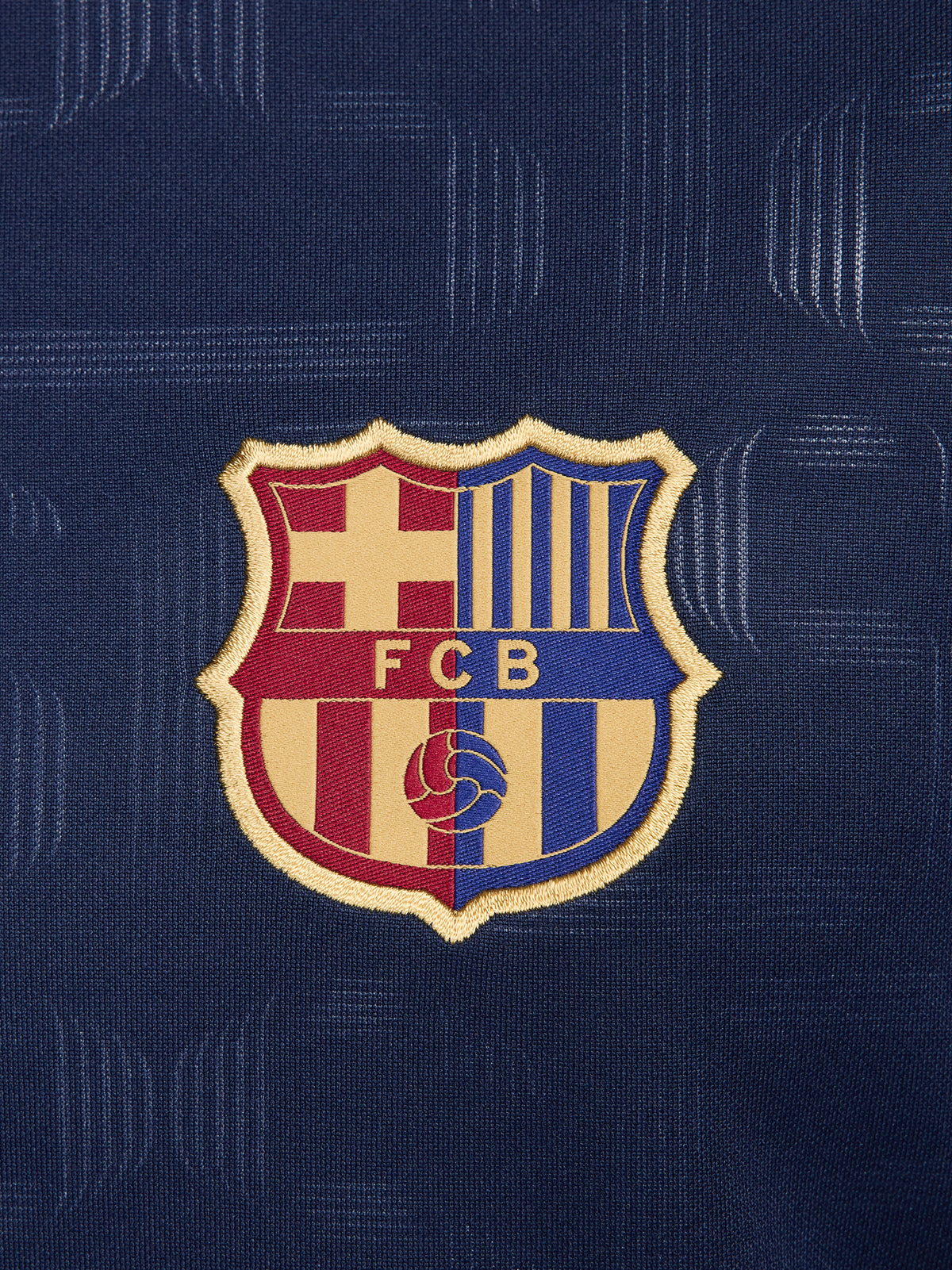 FC Barcelona training shirt in dark navy blue featuring subtle tonal geometric patterns. The shirt displays a golden Nike swoosh on the right chest, the FC Barcelona crest on the left chest, and a bold gold Spotify logo centered across the front.