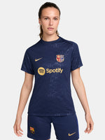 FC Barcelona warm-up shirt featuring a black base with a striking vertical stripe pattern in alternating red and blue. The shirt displays the red Spotify logo in the center, along with the Nike swoosh and FC Barcelona crest, also in red.