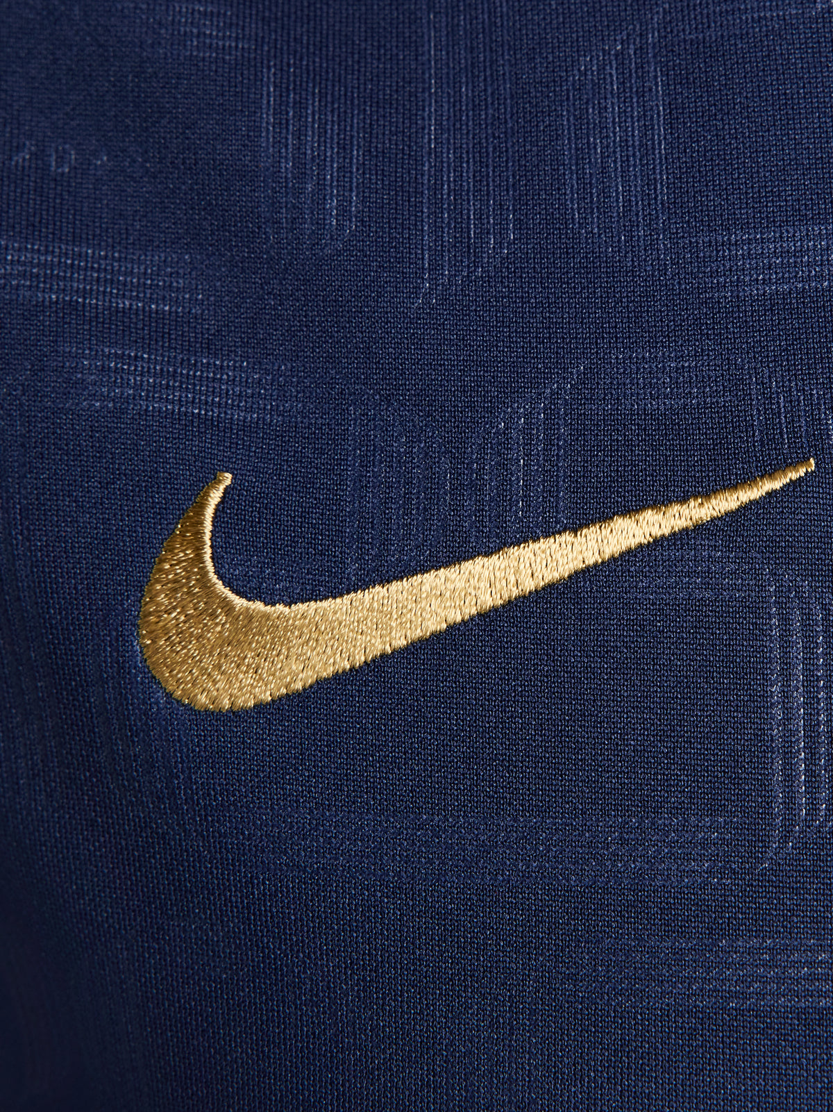 FC Barcelona warm-up shirt featuring a black base with a striking vertical stripe pattern in alternating red and blue. The shirt displays the red Spotify logo in the center, along with the Nike swoosh and FC Barcelona crest, also in red.