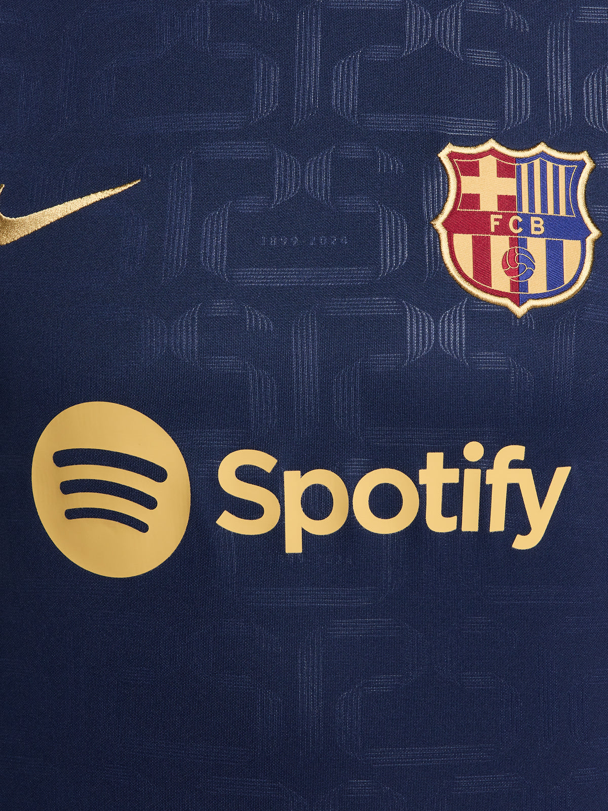 FC Barcelona warm-up shirt featuring a black base with a striking vertical stripe pattern in alternating red and blue. The shirt displays the red Spotify logo in the center, along with the Nike swoosh and FC Barcelona crest, also in red.