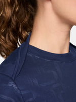 FC Barcelona warm-up shirt featuring a black base with a striking vertical stripe pattern in alternating red and blue. The shirt displays the red Spotify logo in the center, along with the Nike swoosh and FC Barcelona crest, also in red.