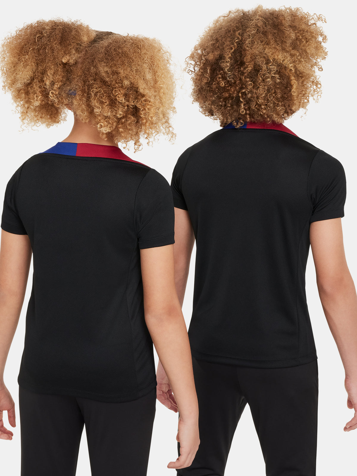 FC Barcelona black kids' training shirt with white Spotify logo and crest, red and blue shoulder details.