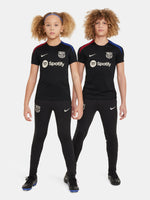 FC Barcelona black kids' training shirt with white Spotify logo and crest, red and blue shoulder details.