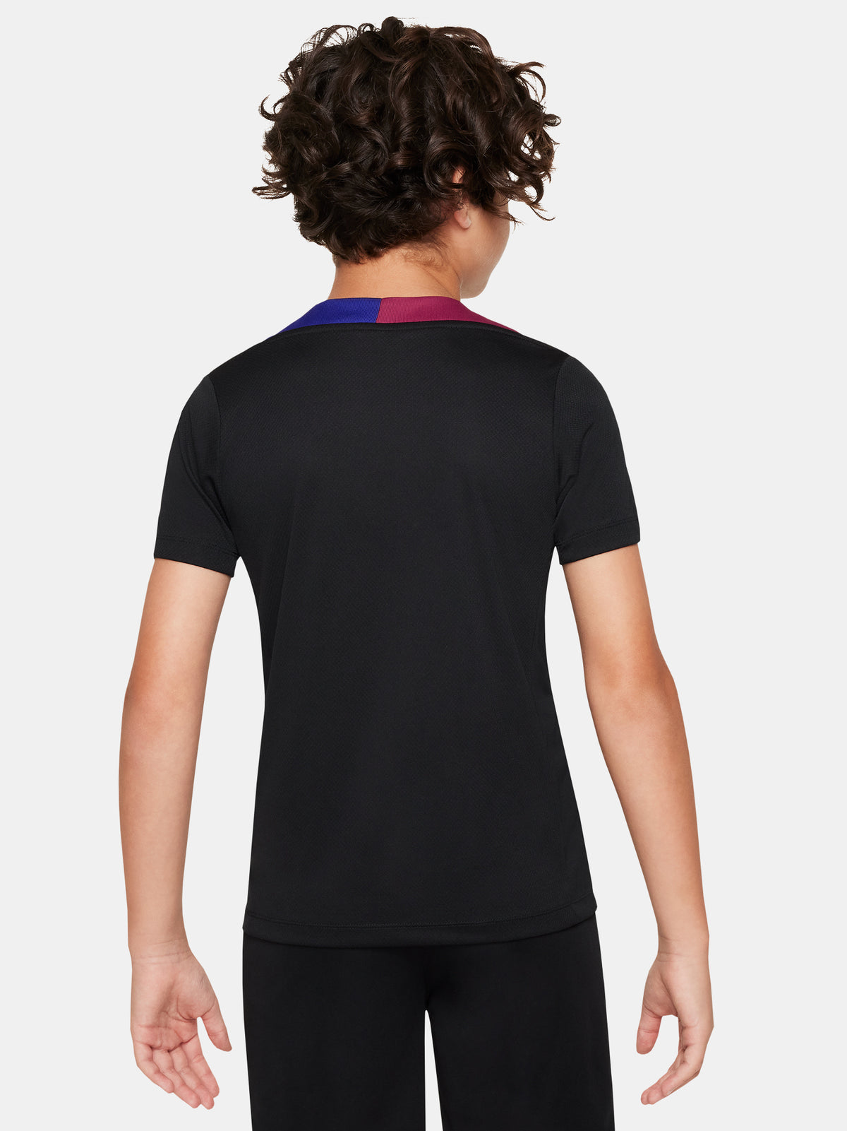 FC Barcelona black kids' training shirt with white Spotify logo and crest, red and blue shoulder details.