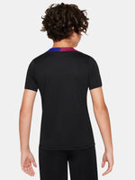 FC Barcelona black kids' training shirt with white Spotify logo and crest, red and blue shoulder details.