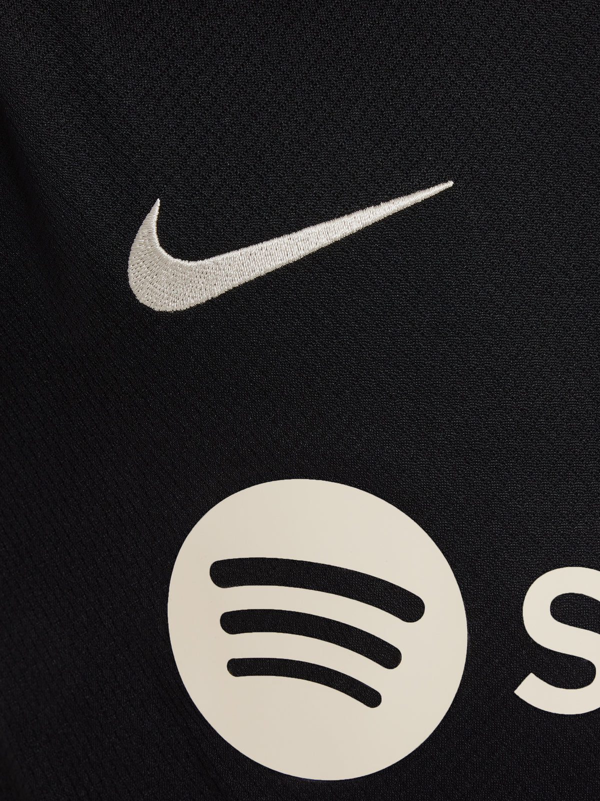 FC Barcelona black kids' training shirt with white Spotify logo and crest, red and blue shoulder details.