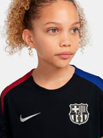 FC Barcelona black kids' training shirt with white Spotify logo and crest, red and blue shoulder details.