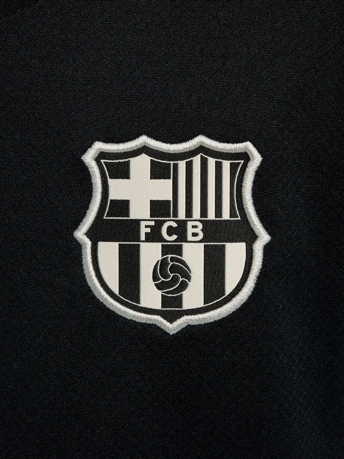FC Barcelona black kids' training shirt with white Spotify logo and crest, red and blue shoulder details.