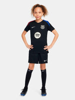 FC Barcelona black kids' training shirt with white Spotify logo and crest, red and blue shoulder details.