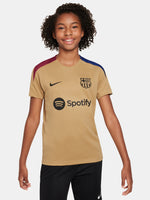 Child wearing an FC Barcelona gold training shirt with short sleeves, red and blue shoulder accents, Nike logo, and Spotify sponsor logo on the chest.




